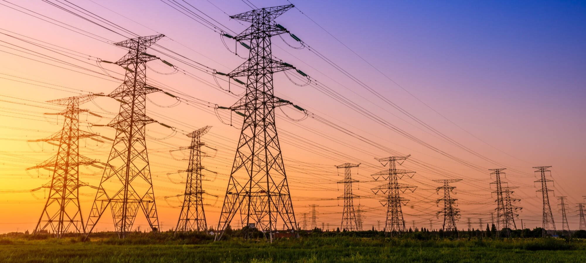 Multiple electricity pylons sunset background ersg